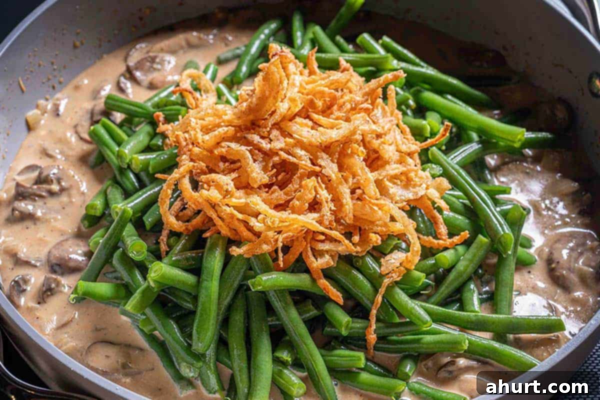 Velvety Green Bean Casserole with a Golden Crunch 9 Mushroom soup combined with green beans and fired onion rings on the top