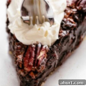 Decadent Chocolate Pecan Pie 11 A delectable slice of Chocolate Pecan Pie, featuring a rich, fudgy chocolate filling studded with pecans, and a golden, flaky crust.