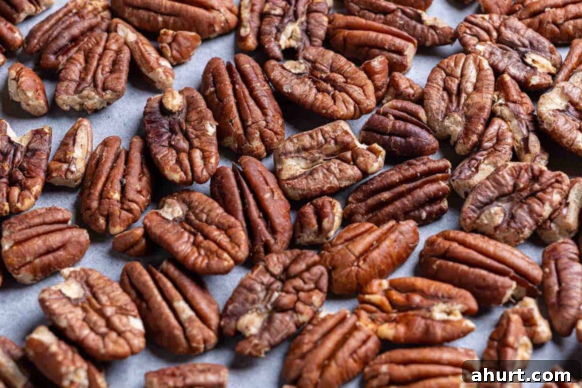 Decadent Chocolate Pecan Pie 5 Fresh, whole pecans spread evenly on a baking tray, ready for toasting to enhance their flavor.