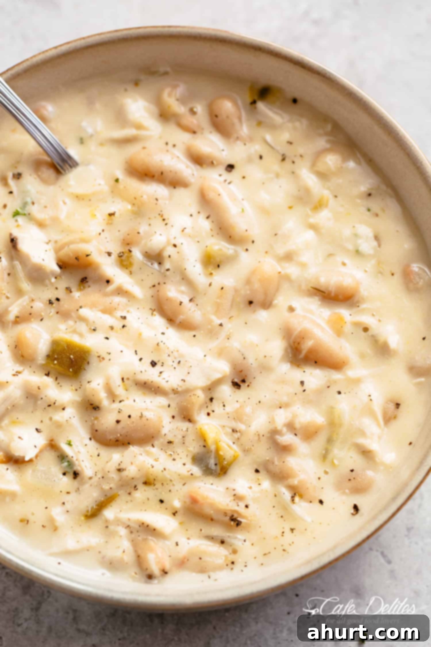 A bowl of turkey chili with white beans #cafedelites #chili #turkey #white #chicken #creamy White Turkey Chili with spoon in a bowl