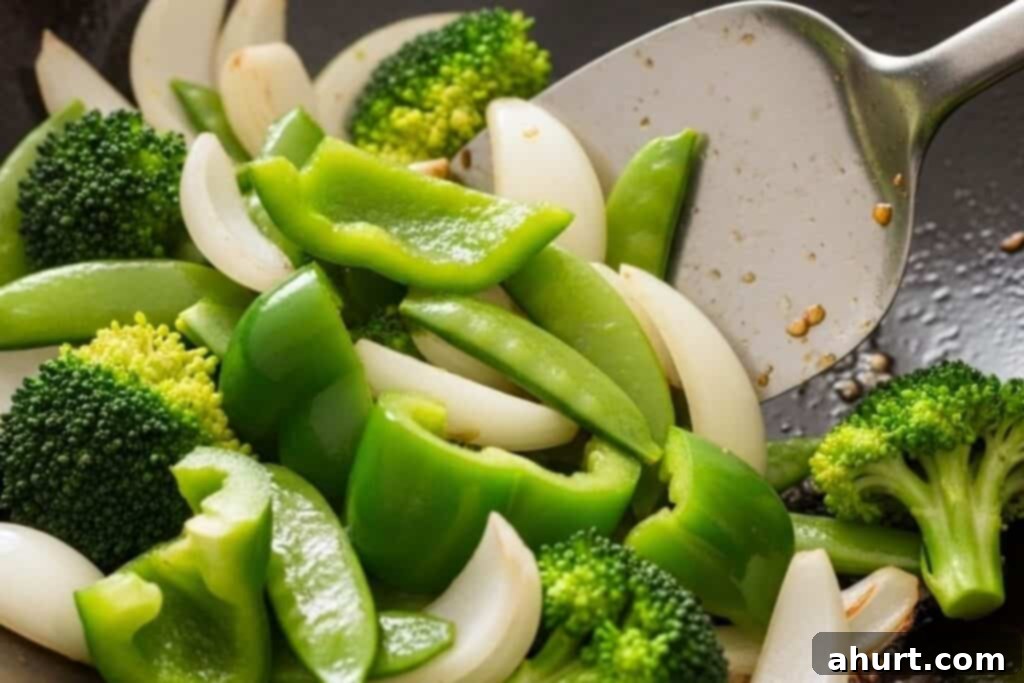 Quick and Delicious Teriyaki Chicken Stir Fry 4 Step 1: Stir-frying colorful vegetables like onion, broccoli, bell pepper, and sugar snap peas in a large wok
