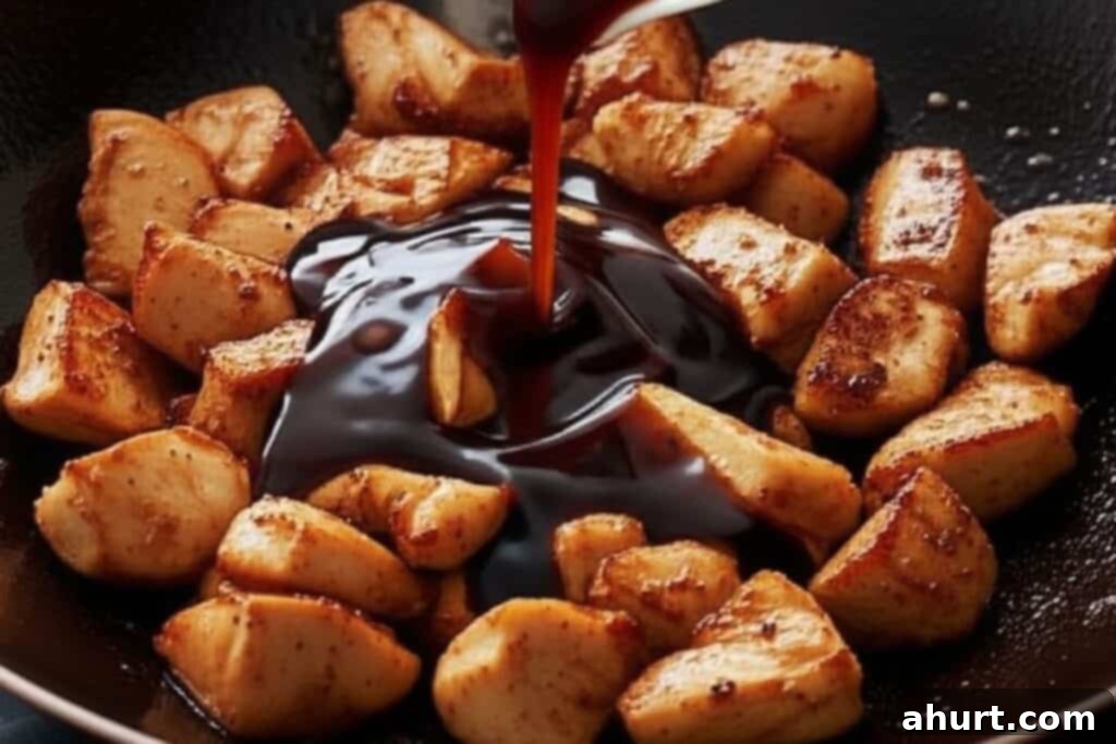 Quick and Delicious Teriyaki Chicken Stir Fry 6 Step 3: Pouring homemade teriyaki sauce, a mixture of soy sauce, brown sugar, vinegar, mirin, and garlic, over the seared chicken