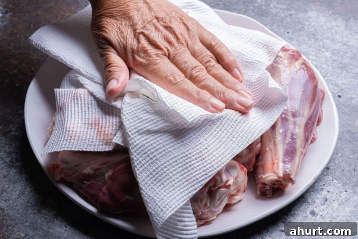 Fall-Off-The-Bone Lamb Shanks 4 Patting dry lamb shanks on a plate to remove moisture before searing.