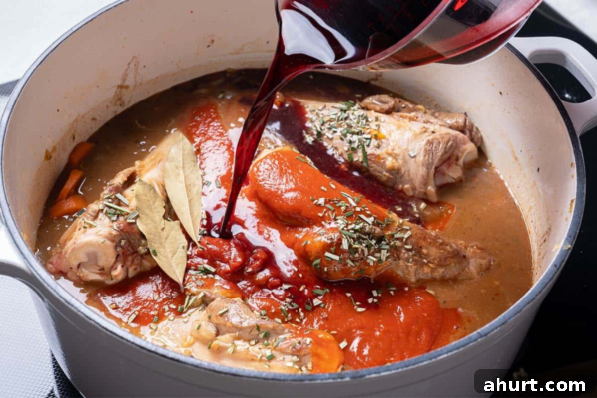 Fall-Off-The-Bone Lamb Shanks 9 Adding stock, red wine, passata, tomato paste, bouillon, and herbs to the pot with lamb shanks and vegetables.