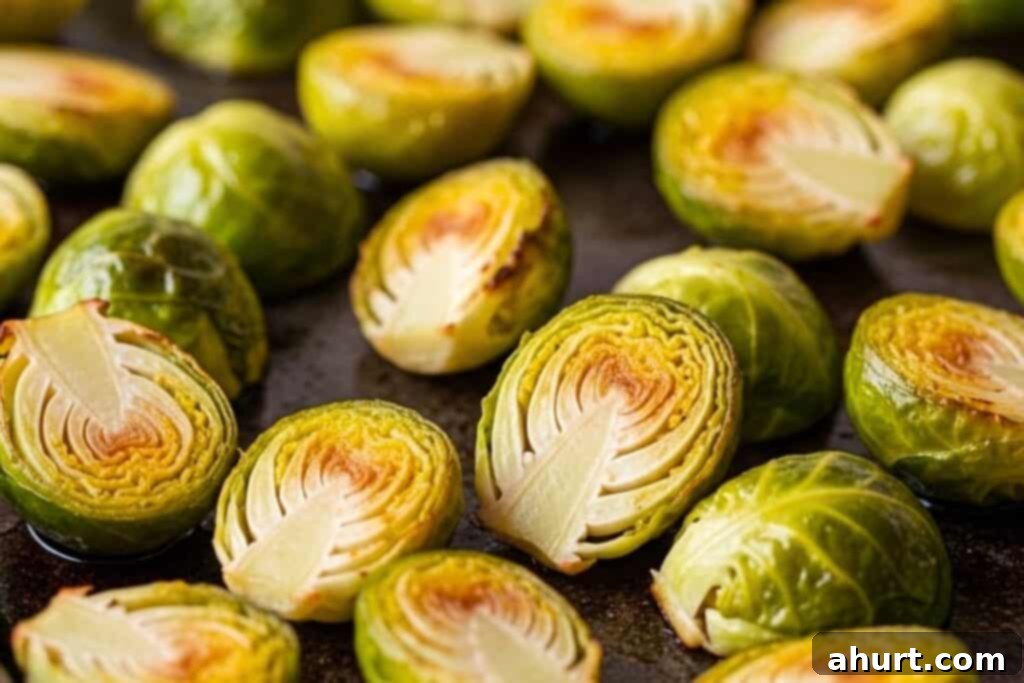 Cheesy Brussels Sprout Delight 7 Brussels sprouts spread evenly on a baking sheet for roasting.