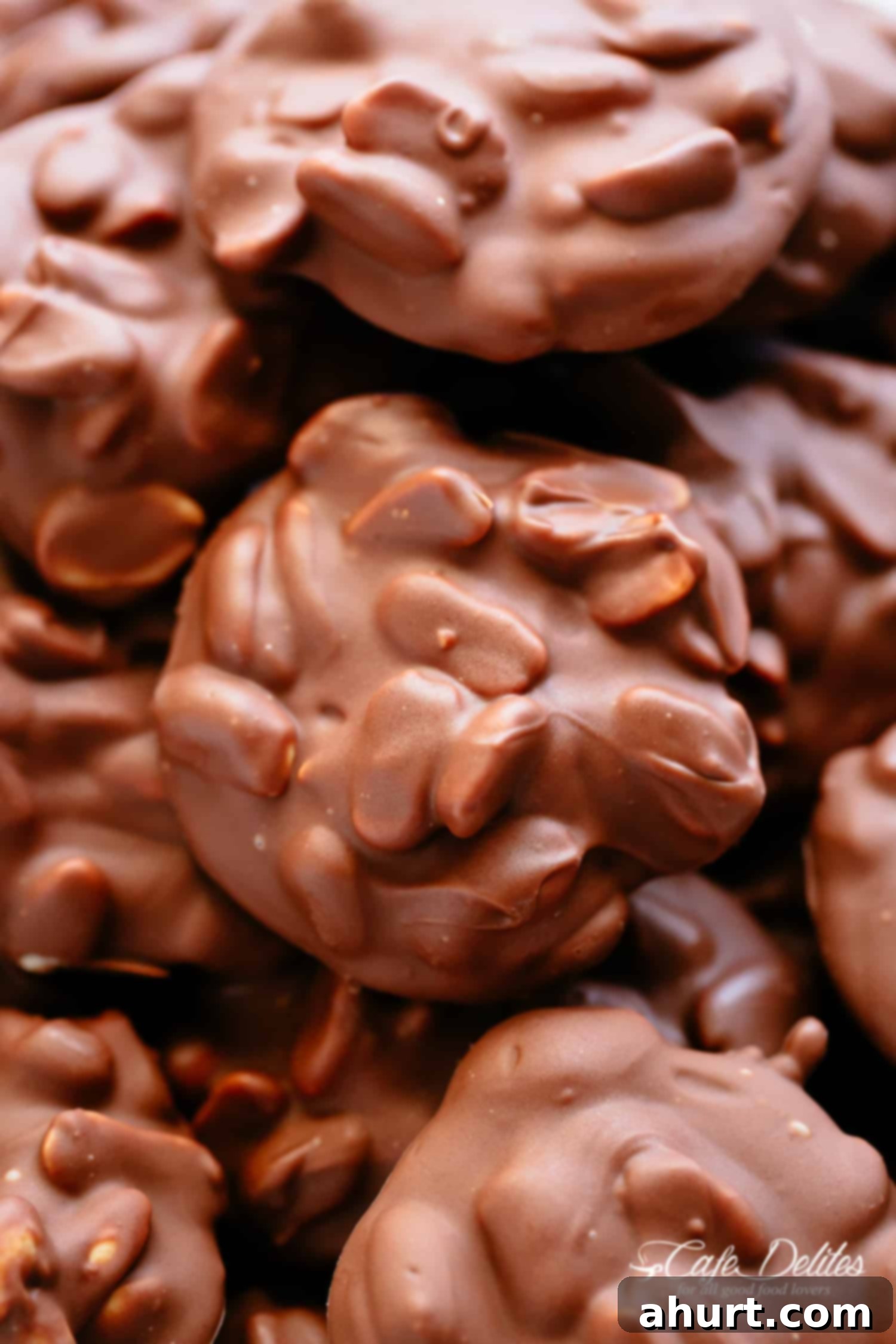 Top view image of freshly made Chocolate Peanut Clusters on parchment paper