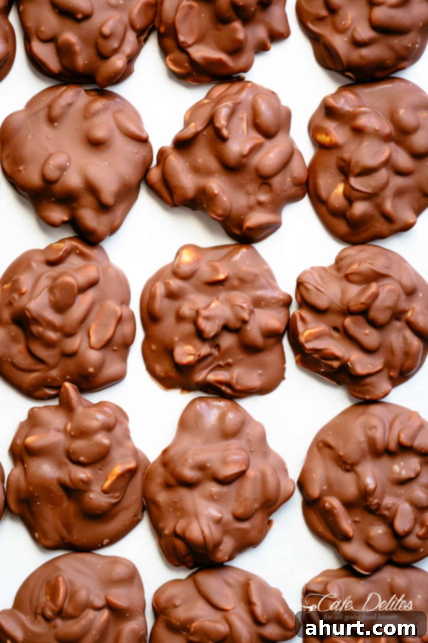 Chocolate Peanut Clusters cooling down on a baking sheet with two melting methods used.
