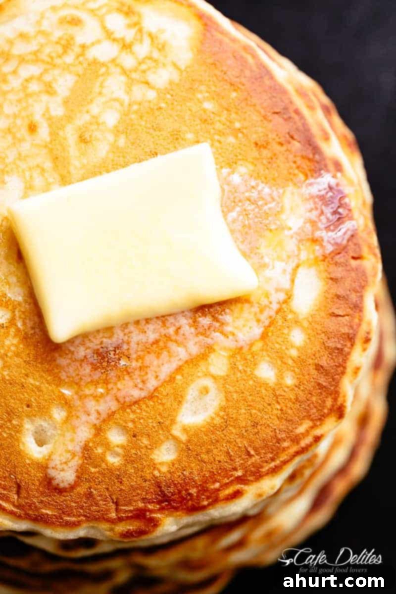 Close-up of fluffy buttermilk pancake batter in a bowl, showing a slight lumpy texture before resting, indicating perfect consistency.