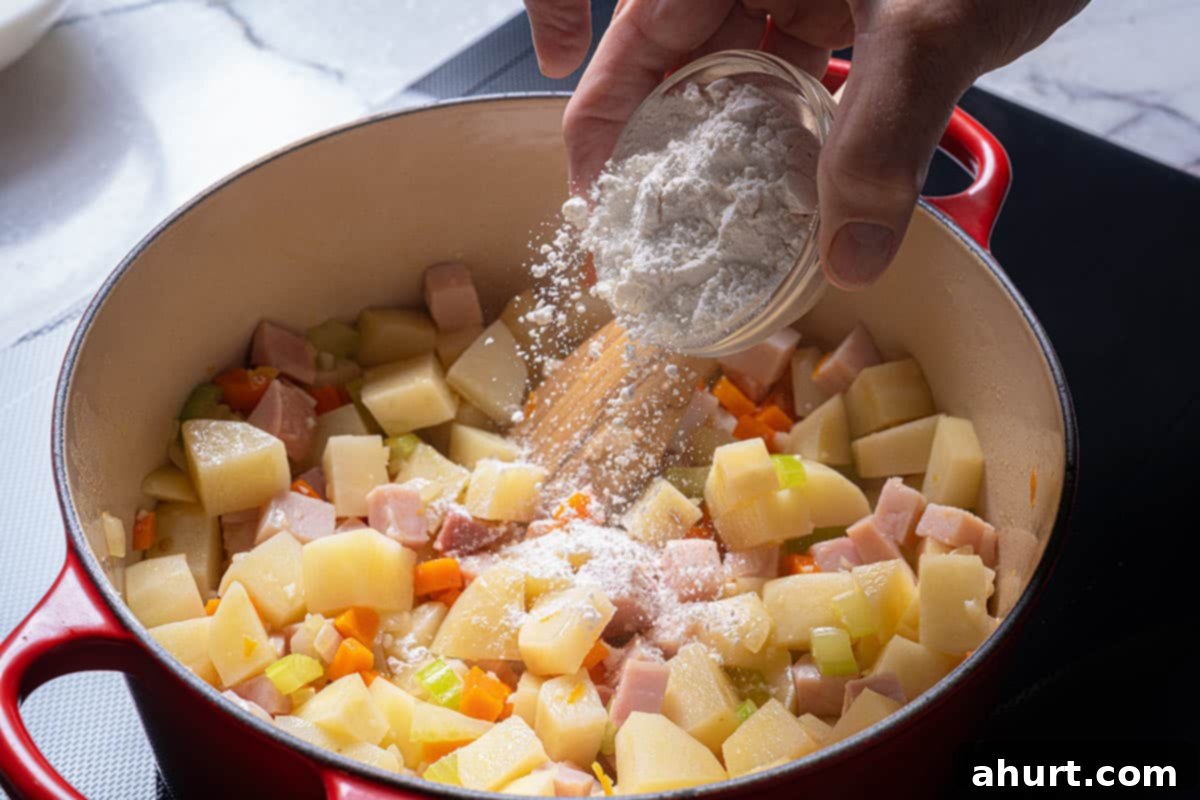 Rich Ham and Potato Chowder 5 Image of flour being added to the mix and cooked.