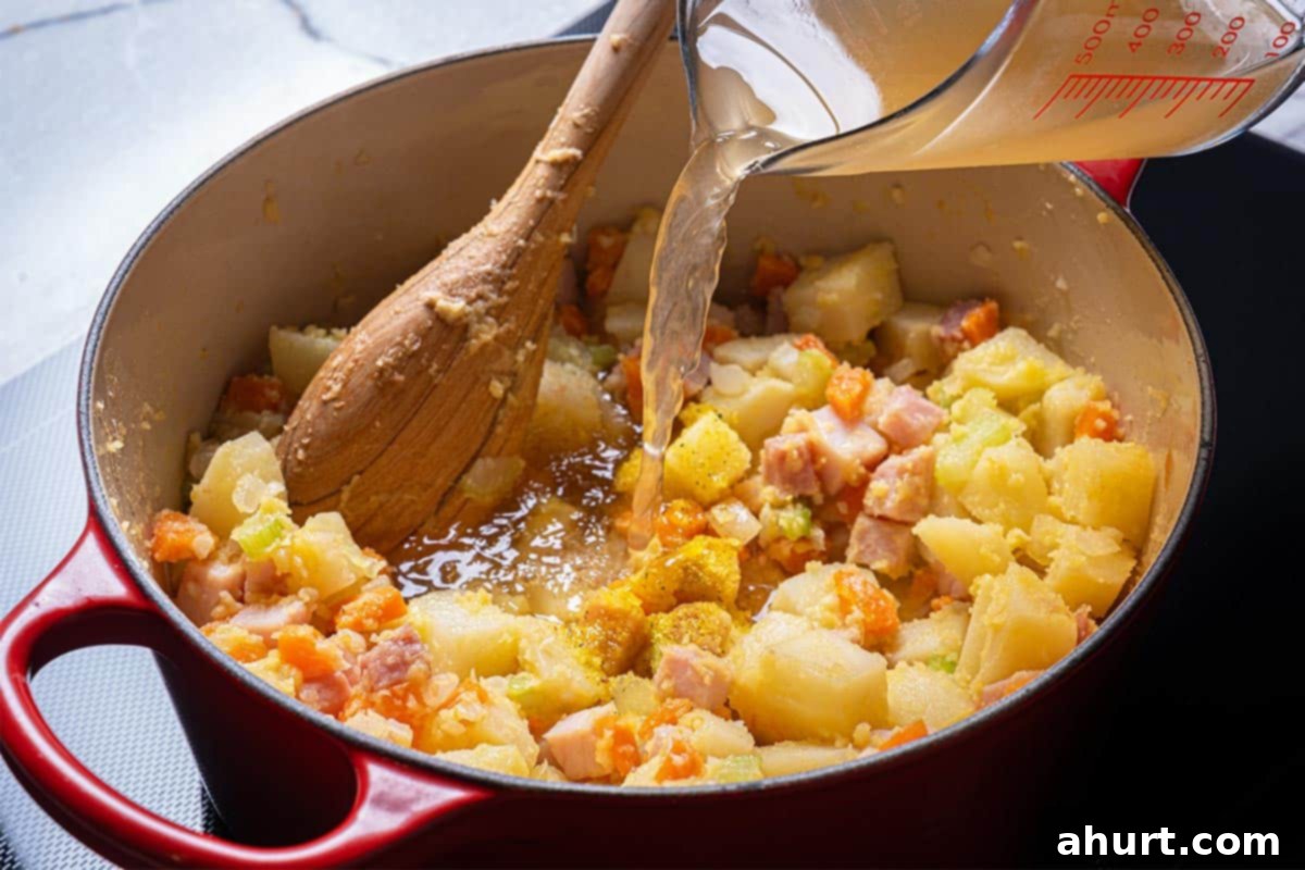 Rich Ham and Potato Chowder 6 Image of stock being added to the mix of veggies.