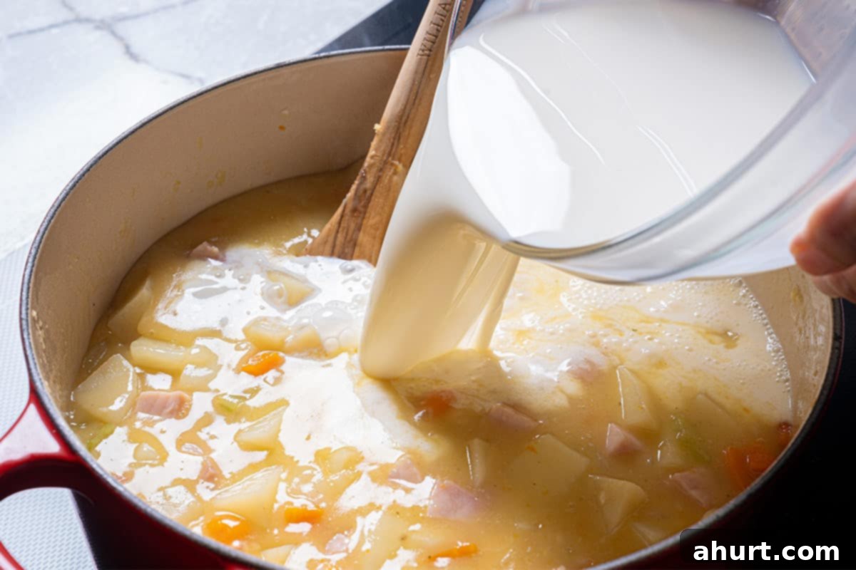 Rich Ham and Potato Chowder 7 Image of milk being added to the mixture.