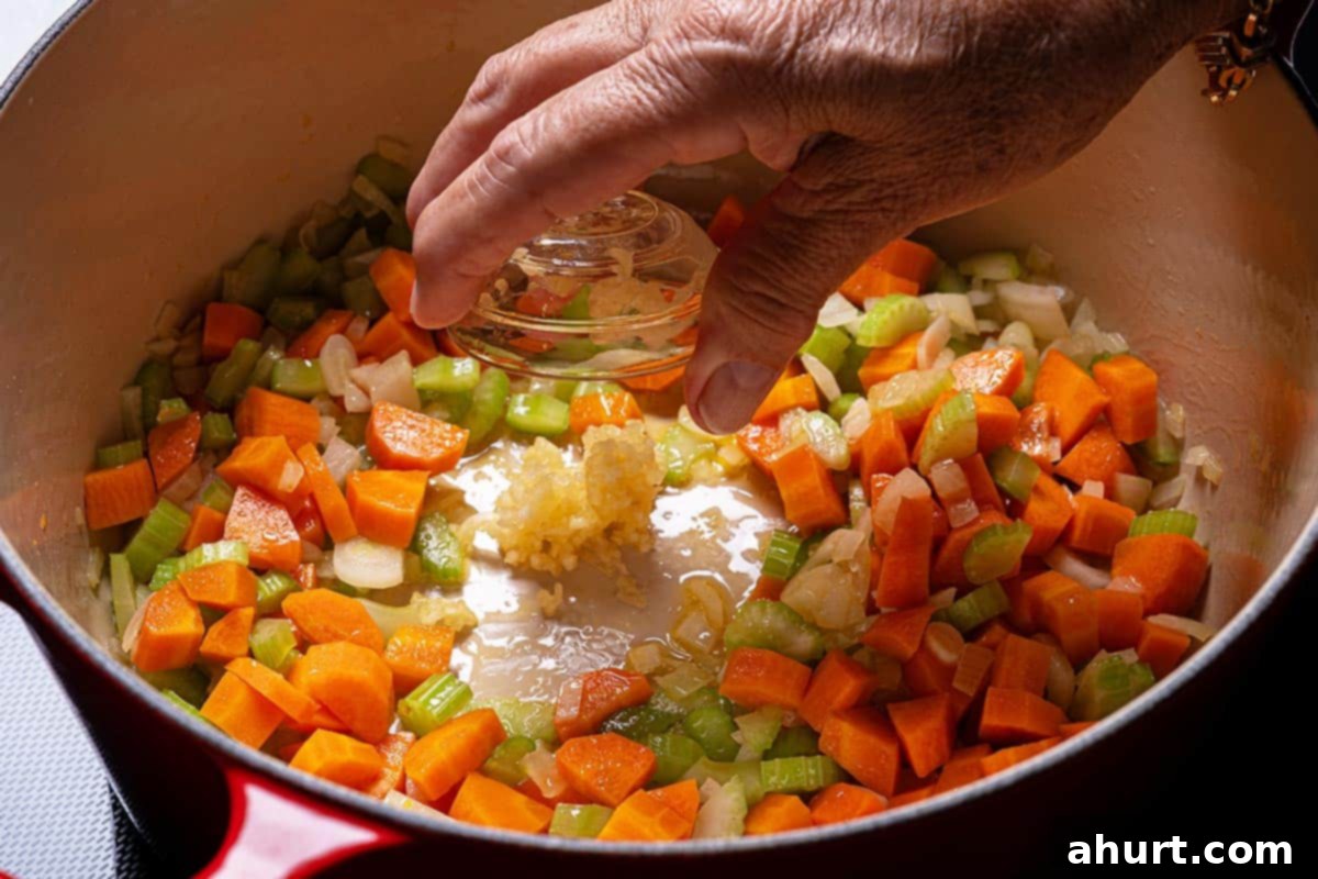 Smoky Ham and White Bean Chowder 4 Step 1: Sautéing diced onions, carrots, and celery in a pot with olive oil.