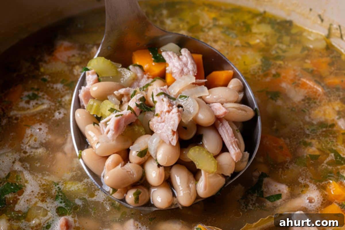 Smoky Ham and White Bean Chowder 7 Step 4: A beautifully plated bowl of ham and bean soup, ready to be served, garnished with fresh herbs.