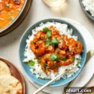 Easy Creamy Coconut Shrimp Curry 13 A plate of Coconut Shrimp with rice, bread and curry.
