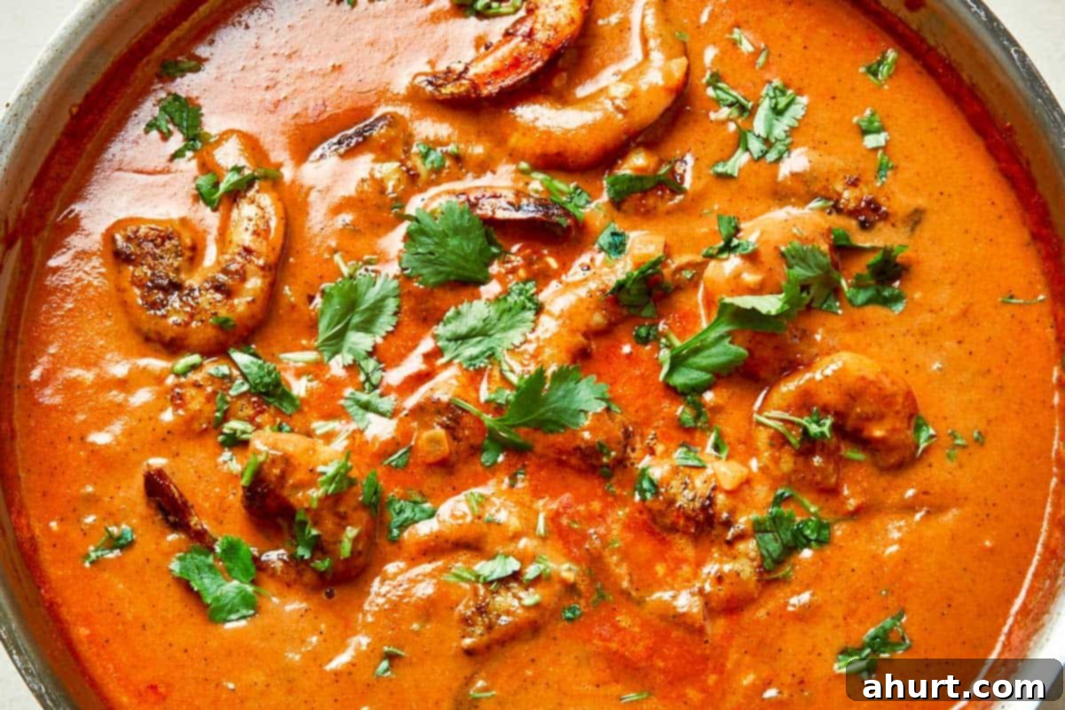 Easy Creamy Coconut Shrimp Curry 10 A pan filled with pink, plump shrimp simmering in a rich sauce, ready to be served.