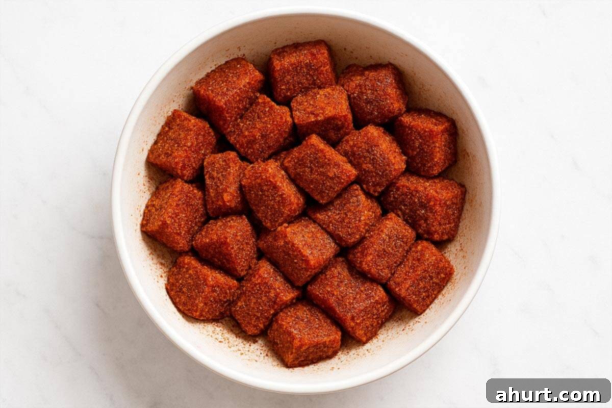 Irresistible Cajun Butter Steak Bites 4 steak in a bowl seasoned with cajun seasoning