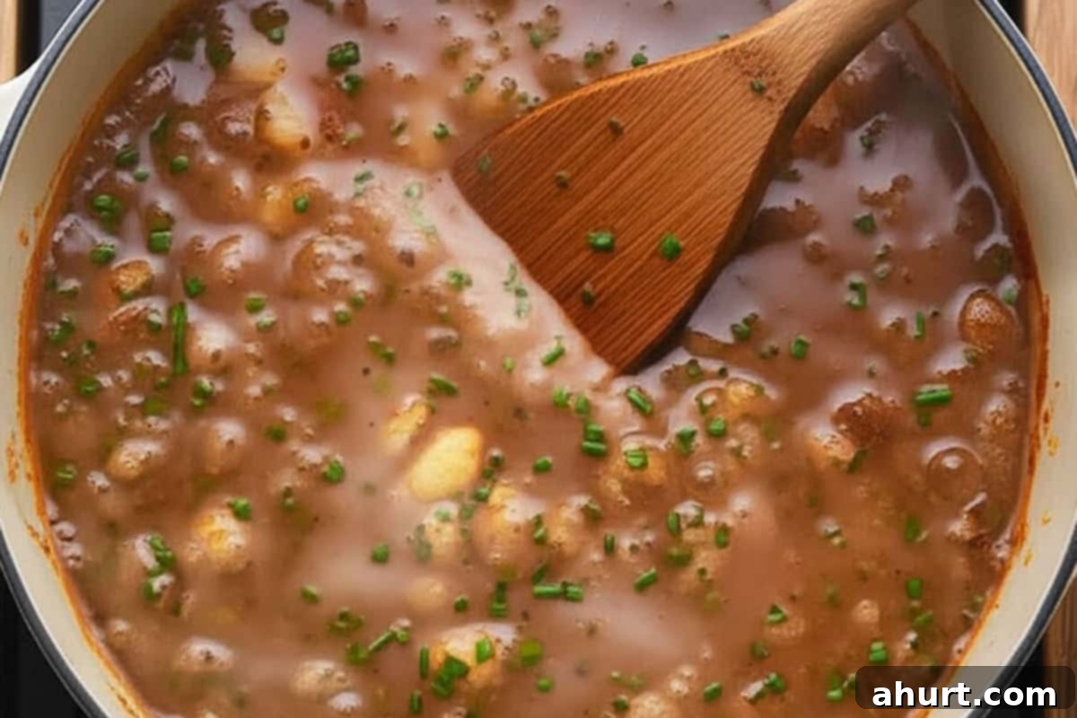 Creamy Cauliflower Comfort 7 Stirring the soup using a wooden spoon.