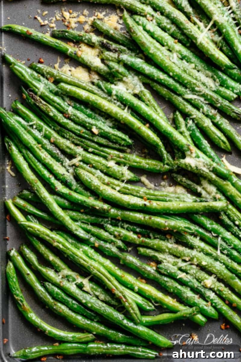 Green Beans #cafedelites #greenbeans #sidedish #oven #roasted #parmesan #garlic Top view of Roasted Green Beans with garlic and parmesan, showing a golden, tender-crisp texture.