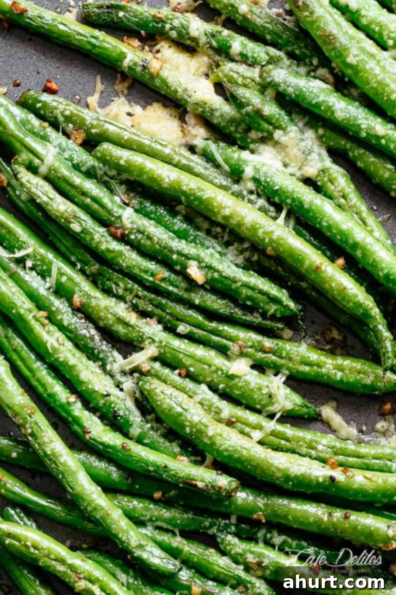 Green beans on a sheet pan with garlic and parmesan #cafedelites #greenbeans #parmesan #garlic Easy Roasted Green Beans with incredible flavor, garnished with parsley.