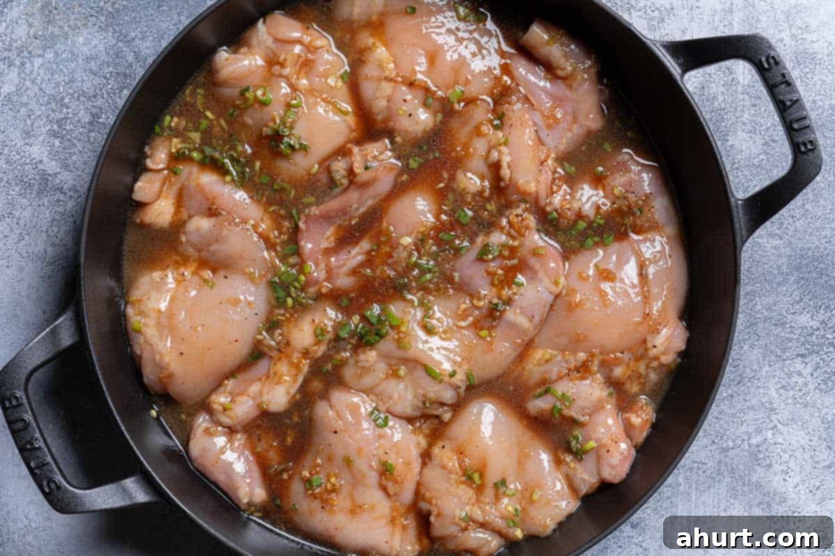 Honey Soy Glazed Chicken Thighs 6 An image of the chicken immersed in the marinade being transferred to the skillet before baking.