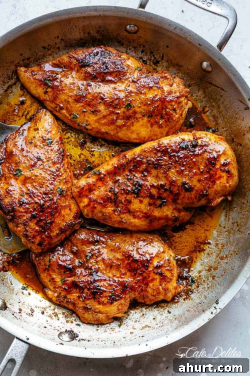 Effortless Buttery Cajun Chicken Breasts 2 Four Spicy Cajun butter chicken breast pieces, slightly charred in a silver pan.