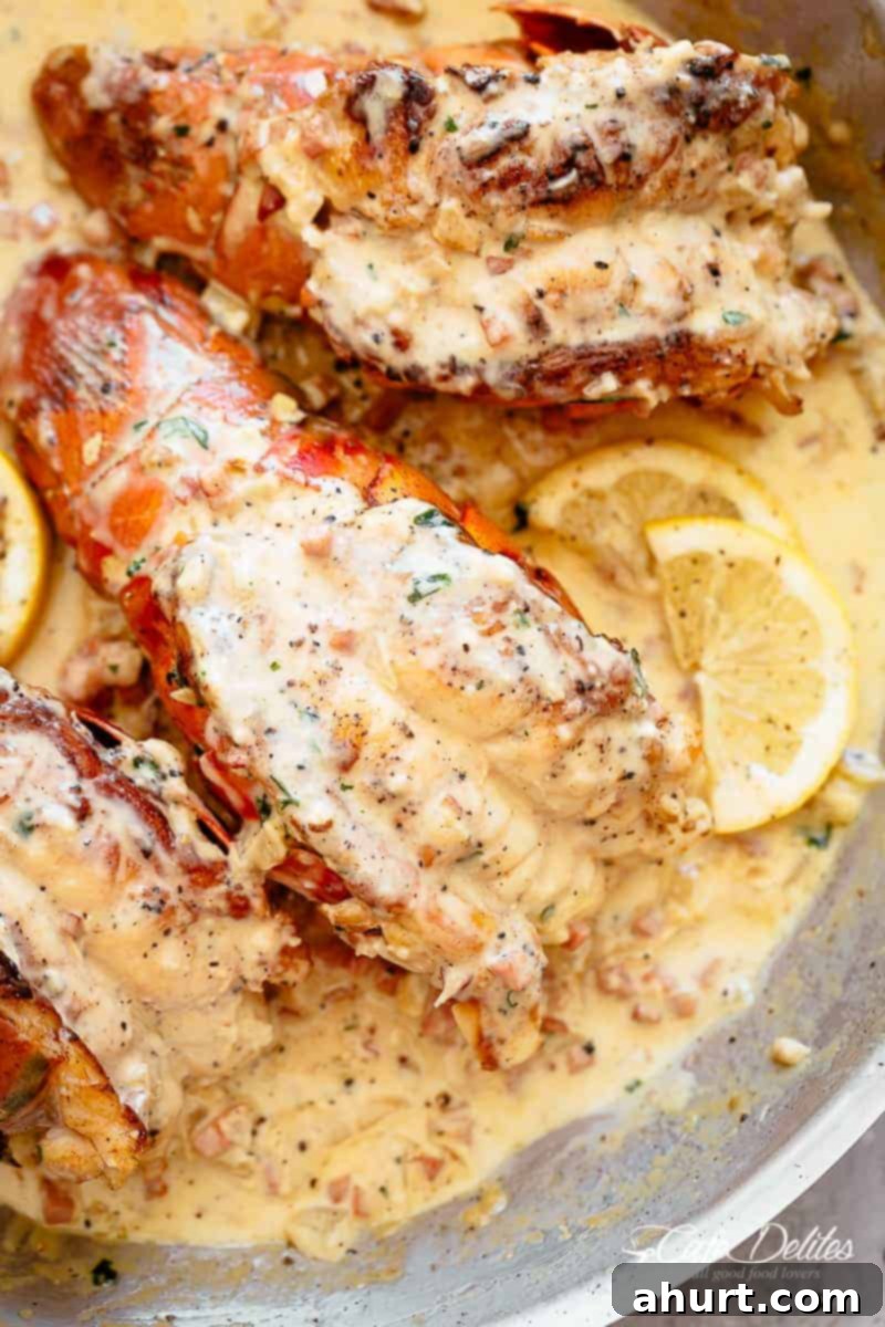 Lobster tails in a skillet pan with creamy bacon sauce #lobster #lobstertails Lobster tails with a creamy bacon sauce and lemon wedges