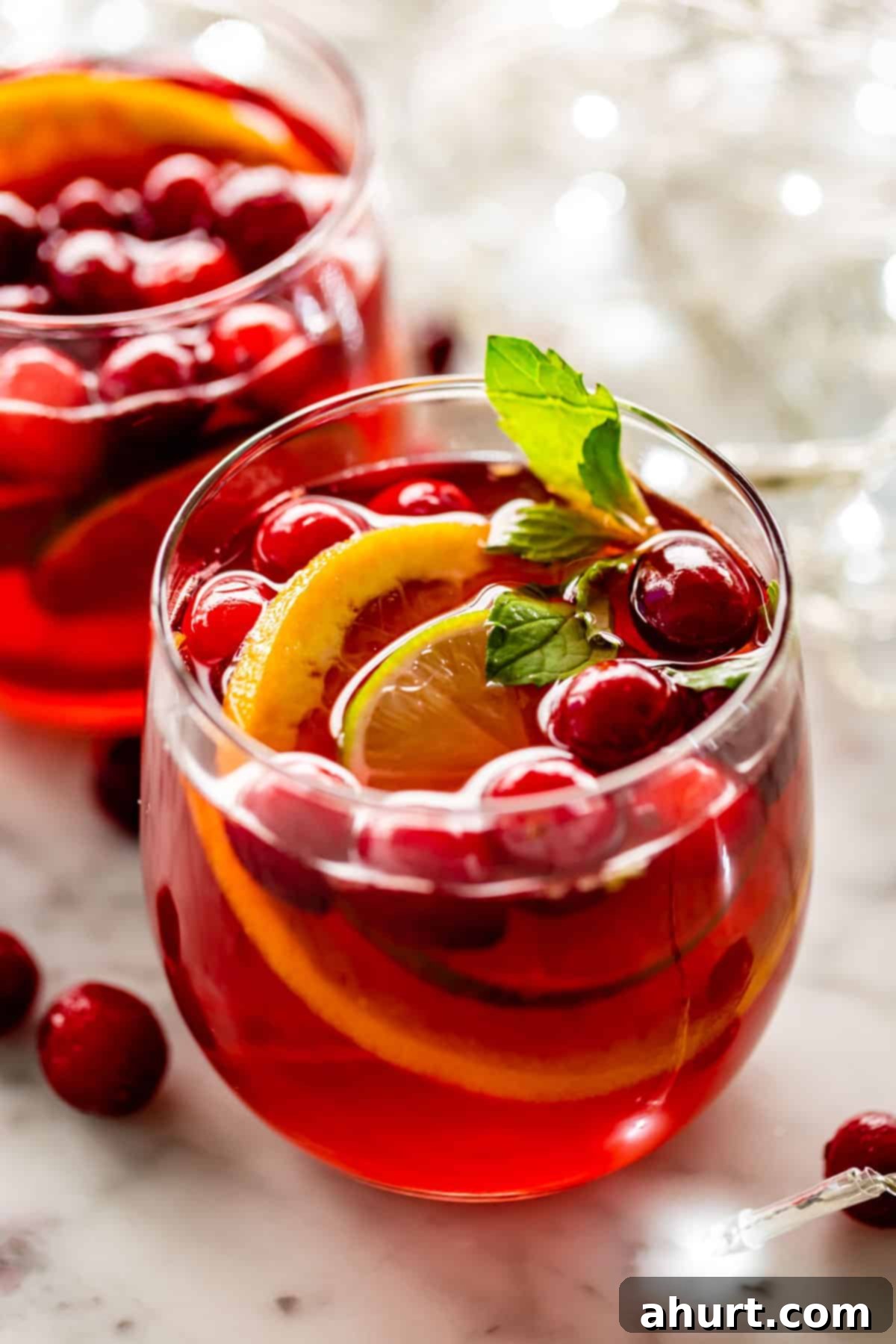 Festive Holiday Punch 6 Close-up of Festive Holiday Punch served in a glass with a lime wedge and mint garnish