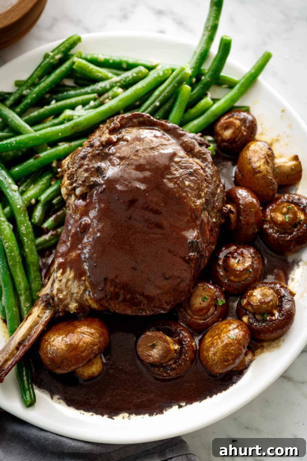 Enjoy Sautéed Buttery Green Beans plated as a side with a juicy prime rib and balsamic soy roasted mushrooms.