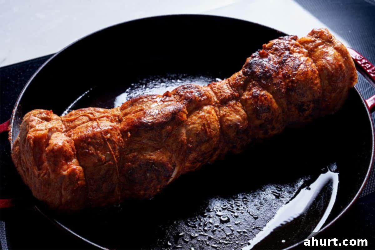 Tender & Juicy Oven-Roasted Pork Loin 4 Pork loin being seared in a hot pan until golden brown.