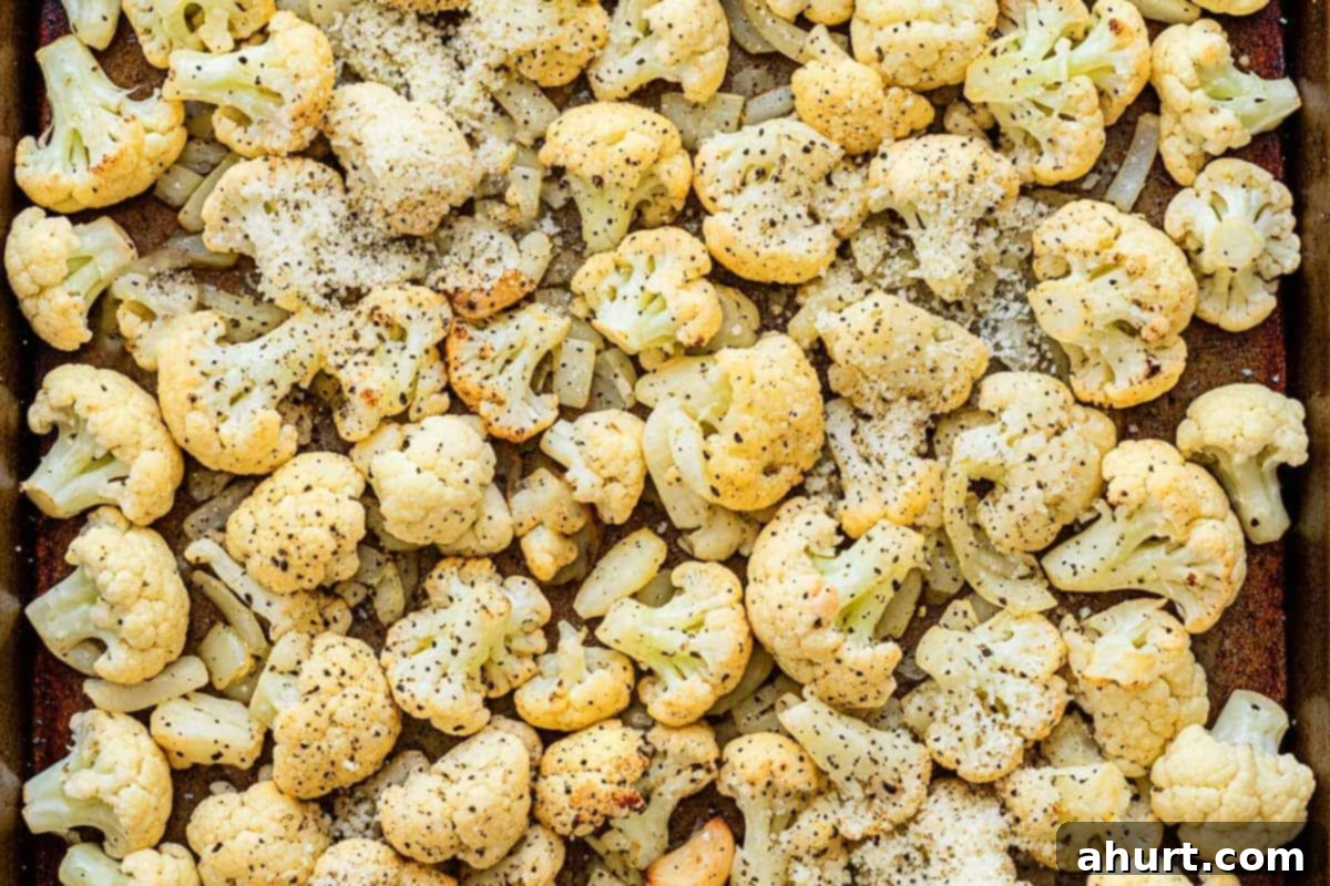 Roasted Cauliflower 7 Roasted cauliflower being sprinkled with freshly grated parmesan cheese.