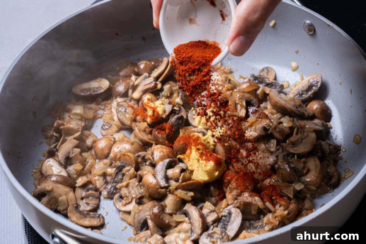 Chicken Stroganoff 5 mushroom and various seasonings being sauted in a pan