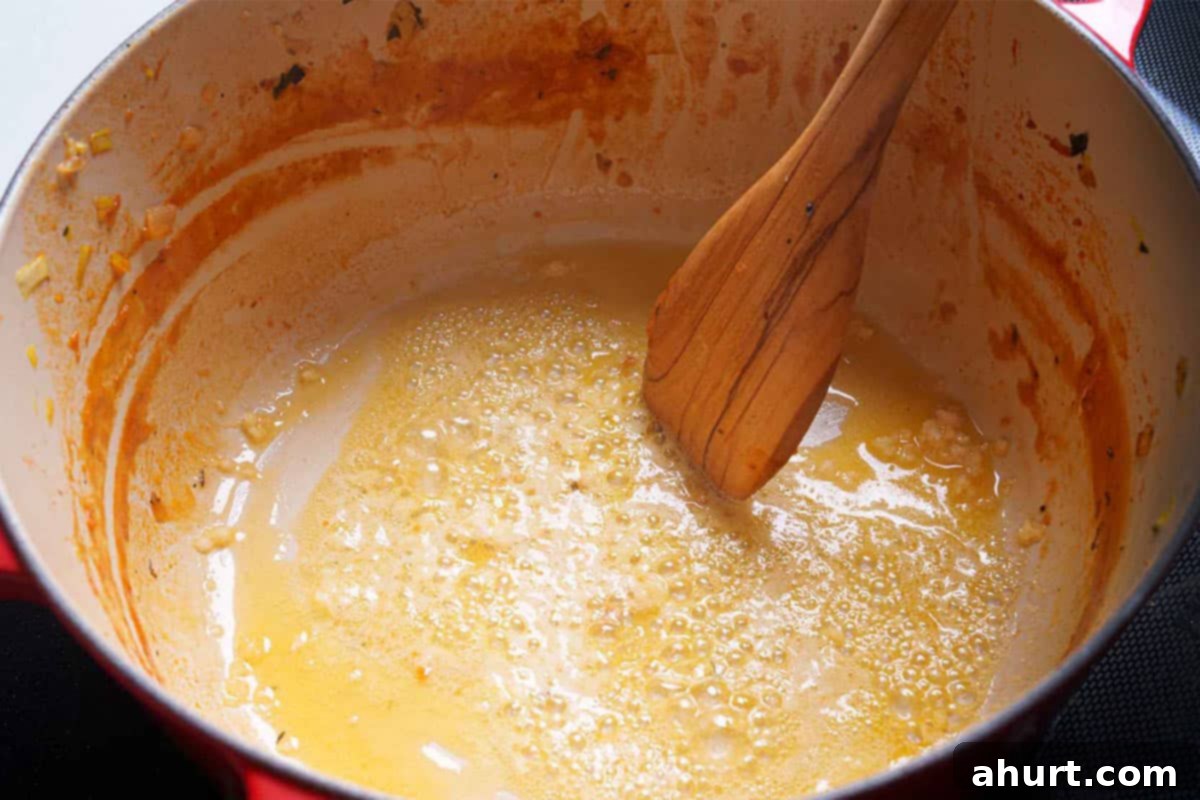 Luxurious Lobster Bisque 12 Butter melting in a pan over medium heat, with minced garlic gently sautéing until wonderfully fragrant and golden.