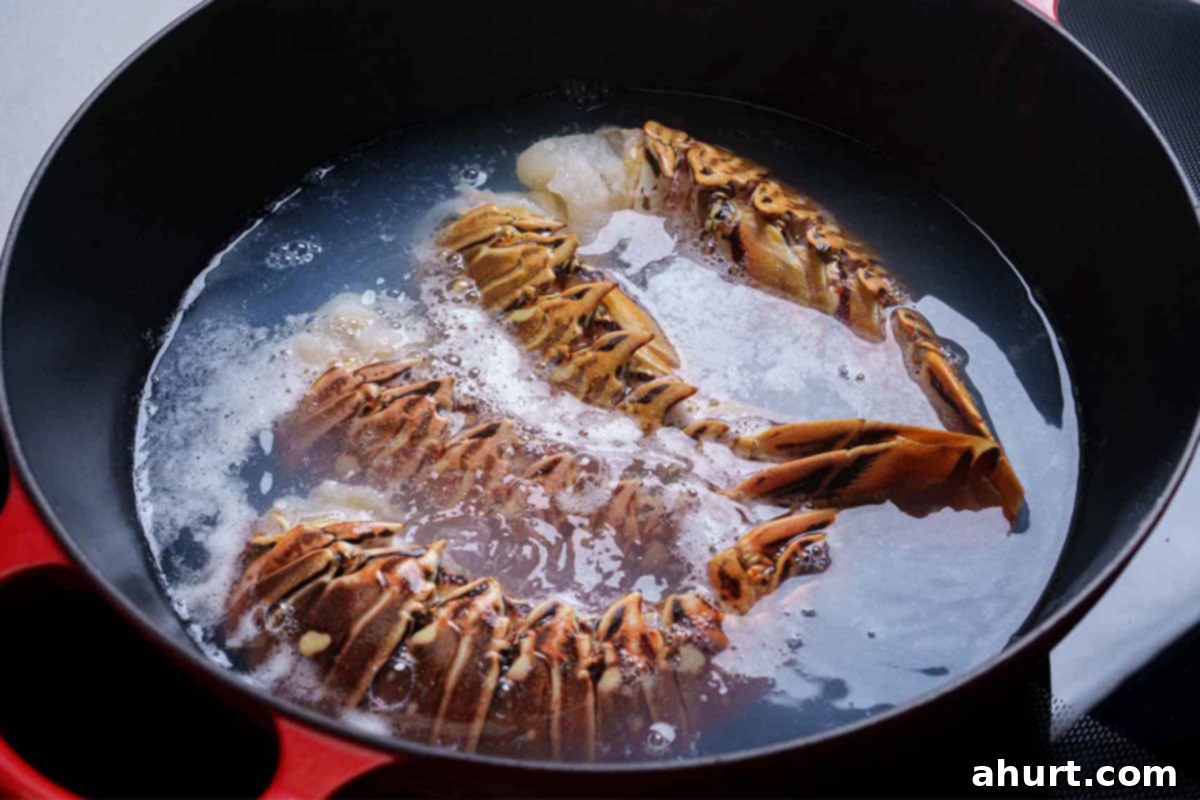Luxurious Lobster Bisque 3 Fresh lobster tails being gently boiled in a large pot of water with a dash of sea salt, turning vibrant red.