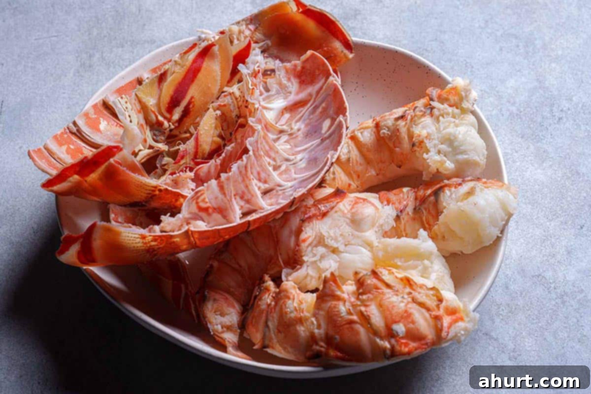 Luxurious Lobster Bisque 5 Cooked lobster tail meat being meticulously separated from its shell, ready for chopping.