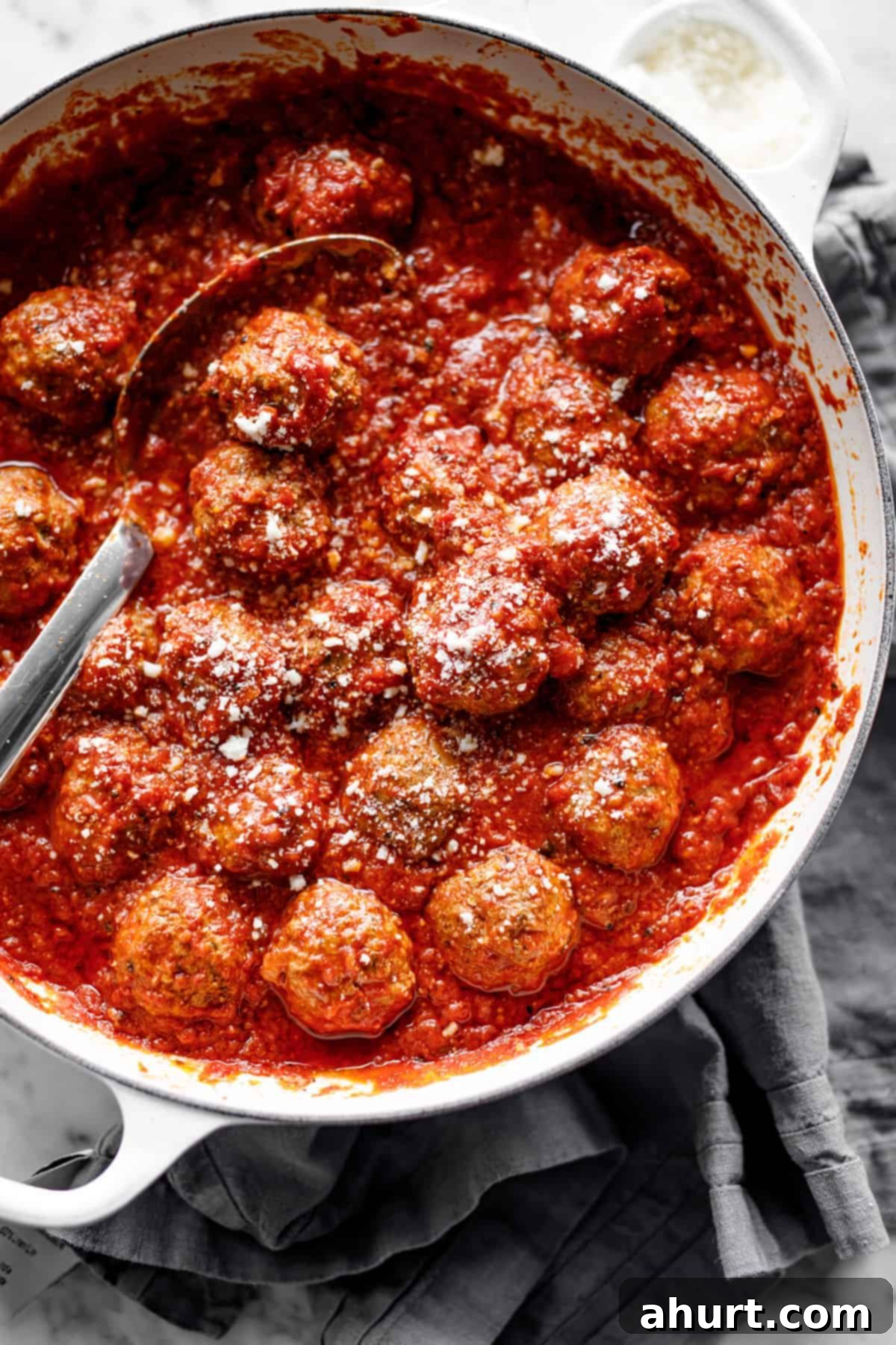 Oven baked meatballs #meatballs #recipe #dinner #italian #homemade Baked Meatballs in vessel with spoon, showcasing their juicy texture in rich tomato sauce.