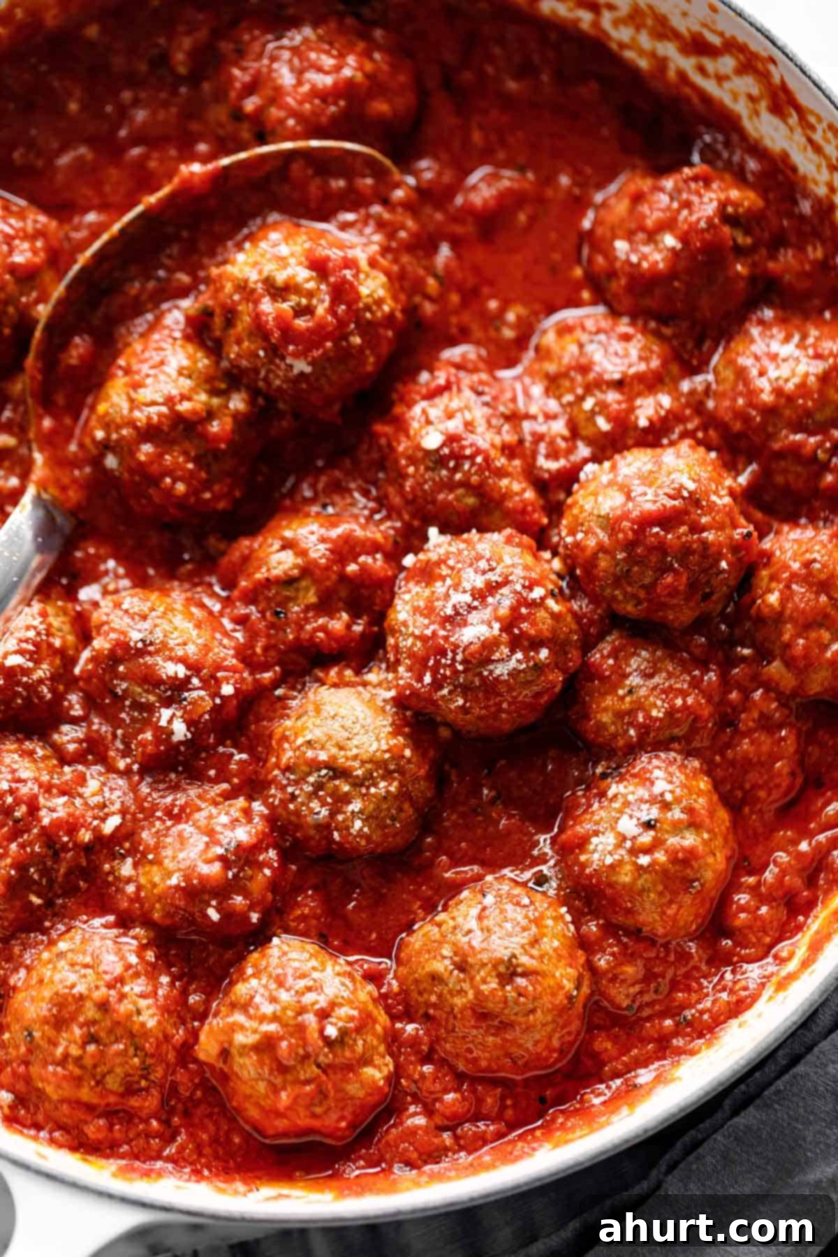 baked meatballs are easy in tomato sauce #homemade #recipe #bakedmeatballs #comfortfood Easy Baked Meatballs in a pan with homemade tomato sauce, garnished with fresh herbs.