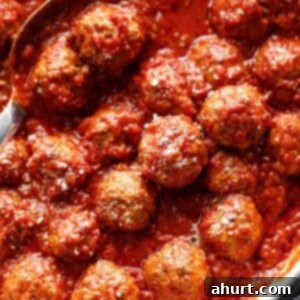 Perfectly Baked Meatballs 2 Easy Baked Meatballs in a pan with tomato sauce