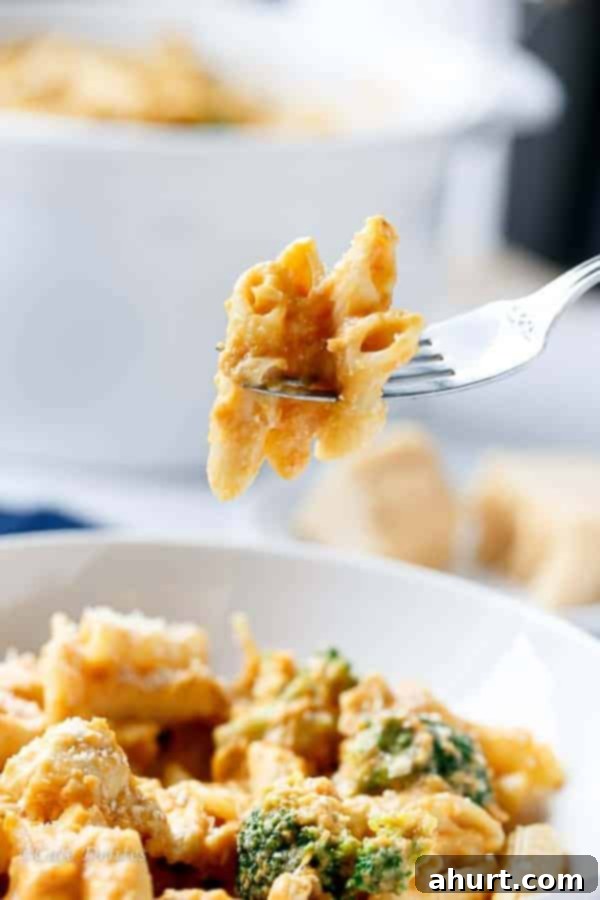 Velvety Pumpkin Chicken Alfredo with Broccoli 10 Fork pierced into pasta from Creamy Pumpkin Chicken and Broccoli Alfredo, with sauce coating the strands