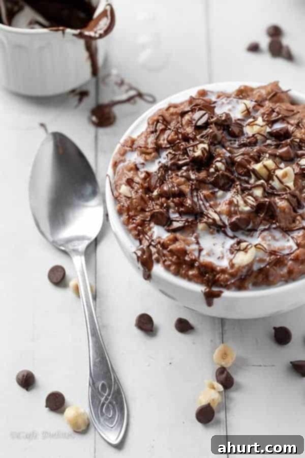 Nutella Hot Chocolate Oatmeal Porridge in a bowl with a silver spoon being kept aside