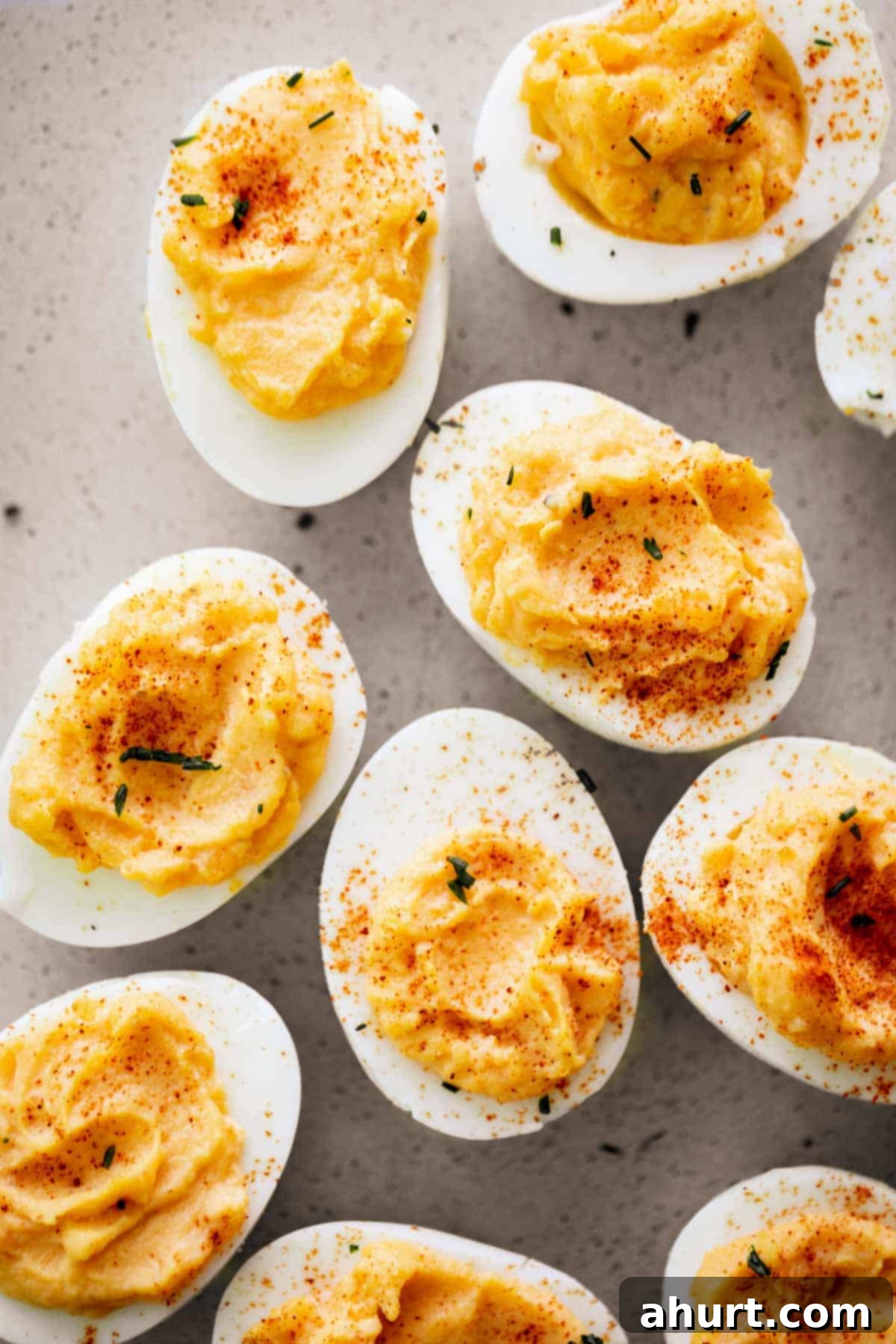 Timeless Deviled Eggs 2 Classic Deviled Eggs on a plate, garnished with paprika and fresh chives, ready to be served.