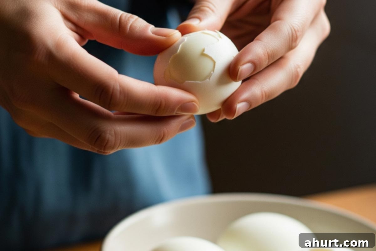 Timeless Deviled Eggs 6 A hand peeling a hard-boiled egg under cold water to aid the process.