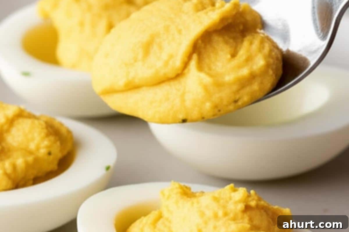 Timeless Deviled Eggs 10 Filling egg white halves with the creamy yolk mixture using a spoon.
