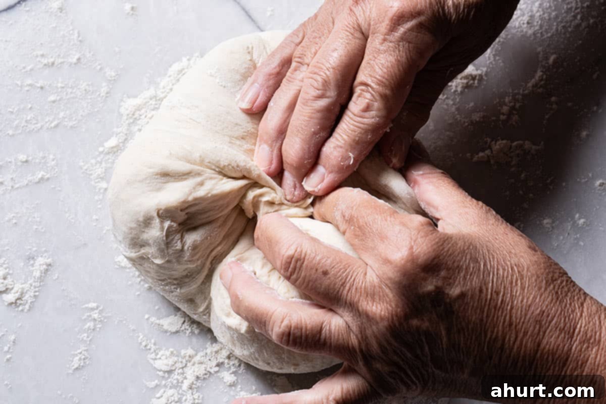 Effortless Artisan Crust: No-Knead Perfection 10 Image of hands folding the though.