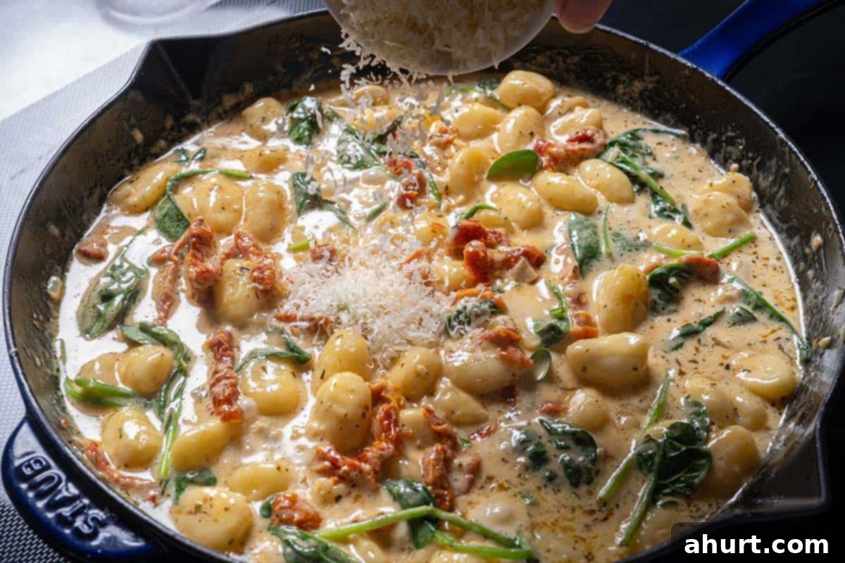 Dreamy Creamy Tuscan Gnocchi 9 Image of finished creamy Tuscan gnocchi in a pan, garnished with basil.