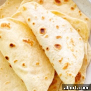 Perfect Homemade Flour Tortillas 11 Freshly prepared Folded flour tortillas on a plate.