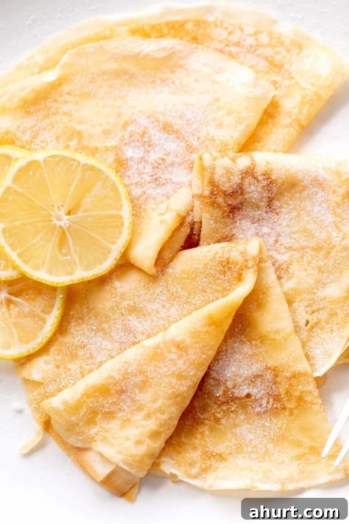 Effortlessly Delicious Crepes 2 3 crepes with lemon slices and caster sugar