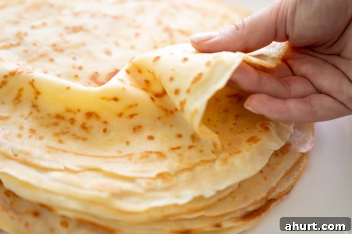 Effortlessly Delicious Crepes 10 Holding a crepe from the top of a stack.