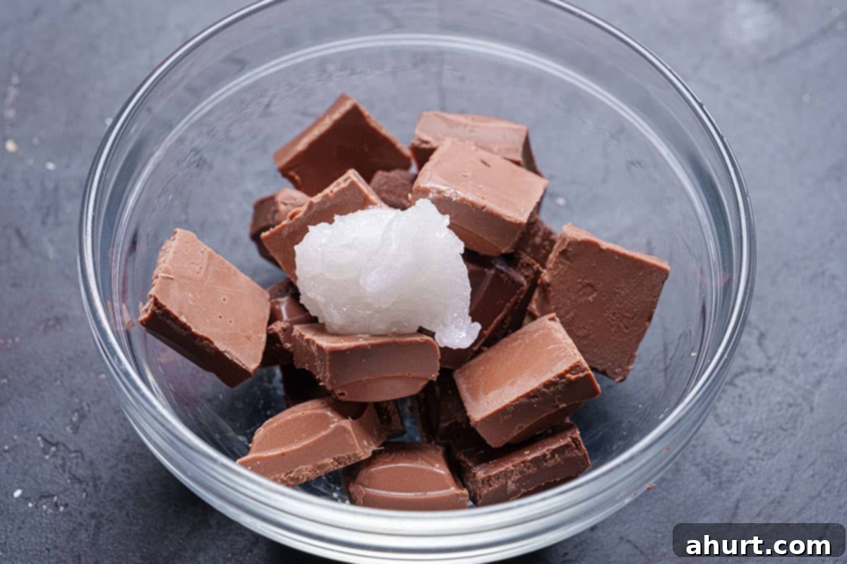 Tipsy Chocolate Strawberries 7 A microwave-safe bowl containing melted semi-sweet and milk chocolate mixed with coconut oil, appearing smooth and glossy.