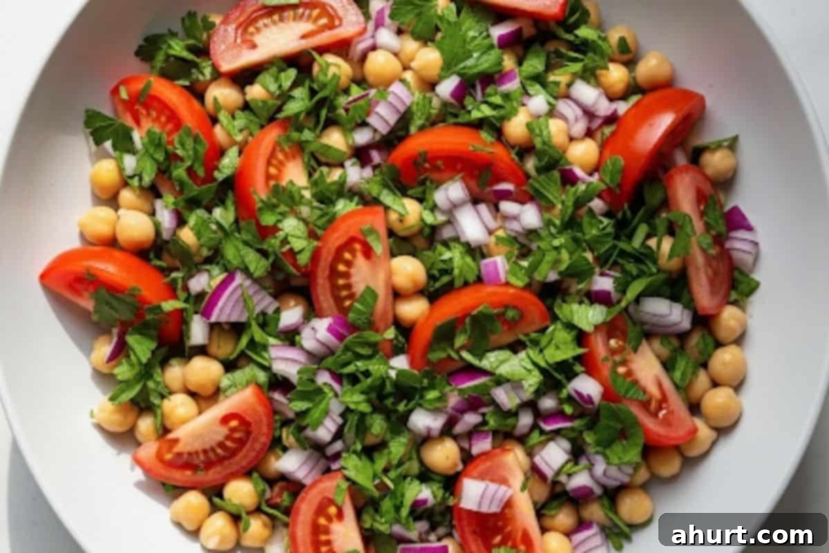 Mediterranean Chickpea Tomato Salad 4 In a large bowl, combine the chickpeas, quartered tomatoes, chopped parsley and finely diced red onion.