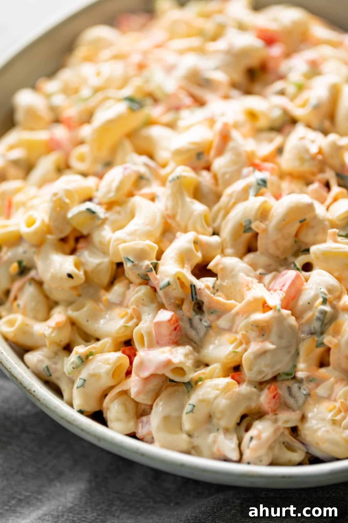 Picnic Perfect Macaroni Salad 5 A super creamy macaroni salad, easy and quick to make, with a delicious creamy mayo dressing and fresh ingredients. Served in a light grey bowl on a grey linen cloth.